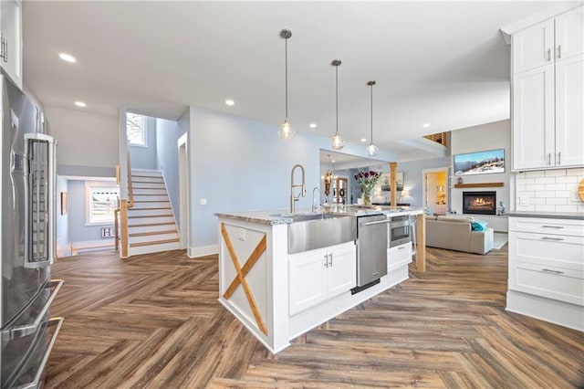 4115 Merritt Dr, Cumming, GA 30041 - kitchen with dark parquet floors, white cabinets, and appliances with stainless steel finishes