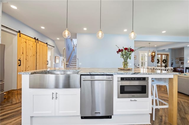 4115 Merritt Dr, Cumming, GA 30041 - kitchen featuring a barn door, sink, white cabinets, and appliances with stainless steel finishes