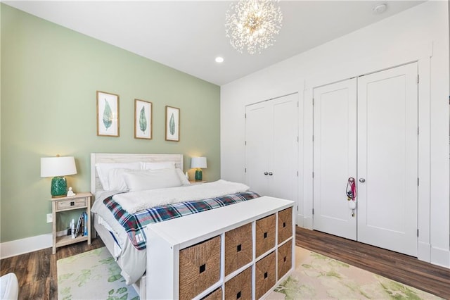 4115 Merritt Dr, Cumming, GA 30041 - bedroom featuring dark wood-type flooring, multiple closets, and a notable chandelier