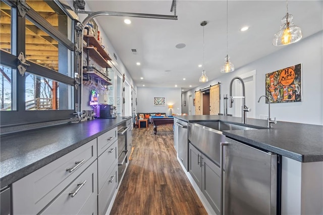 4115 Merritt Dr, Cumming, GA 30041 - kitchen featuring dark wood-type flooring, sink, dishwashing machine, pendant lighting, and a barn door
