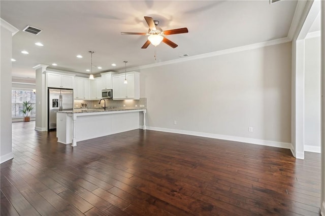 kitchen featuring dark wood-type flooring, kitchen peninsula, stainless steel appliances, pendant lighting, and white cabinetry