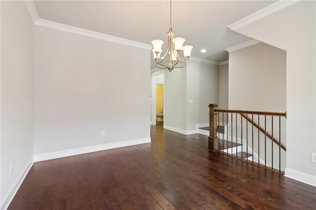 empty room with ornamental molding, dark wood-type flooring, and a chandelier