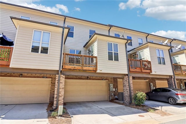 multi unit property featuring central AC unit, a garage, and a balcony