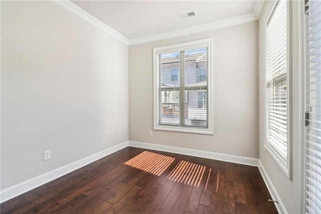 spare room featuring ornamental molding and dark hardwood / wood-style flooring