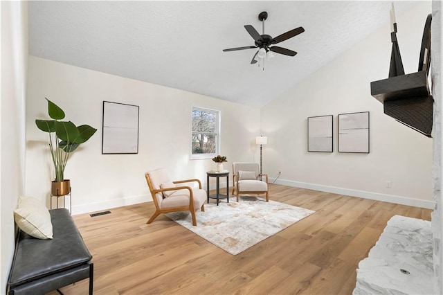 living area featuring vaulted ceiling, ceiling fan, and light hardwood / wood-style floors