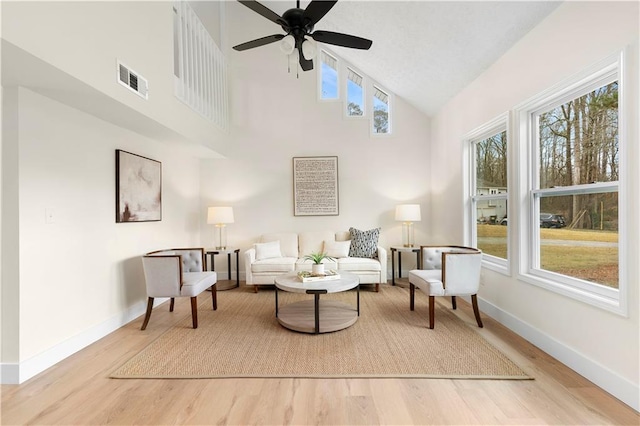 living area featuring high vaulted ceiling, hardwood / wood-style floors, and ceiling fan