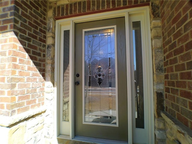 view of exterior entry with brick siding