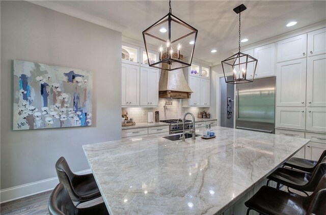 16 Cambridge Way, Cartersville, GA 30121 - kitchen with built in refrigerator, a chandelier, custom exhaust hood, white cabinets, and backsplash