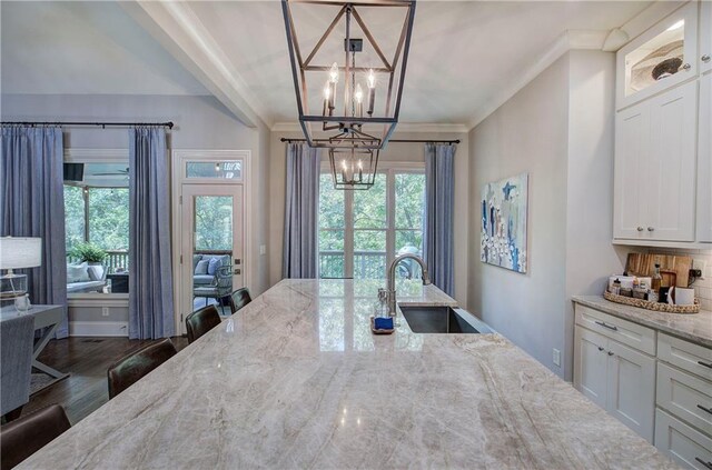 16 Cambridge Way, Cartersville, GA 30121 - kitchen featuring a chandelier, healthy amount of natural light, light stone counters, white cabinetry, and ornamental molding