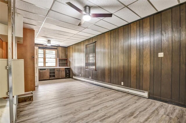 3137 Ardley Rd SW, Atlanta, GA 30311 - unfurnished room featuring baseboard heating, ceiling fan, wood finished floors, wooden walls, and a paneled ceiling
