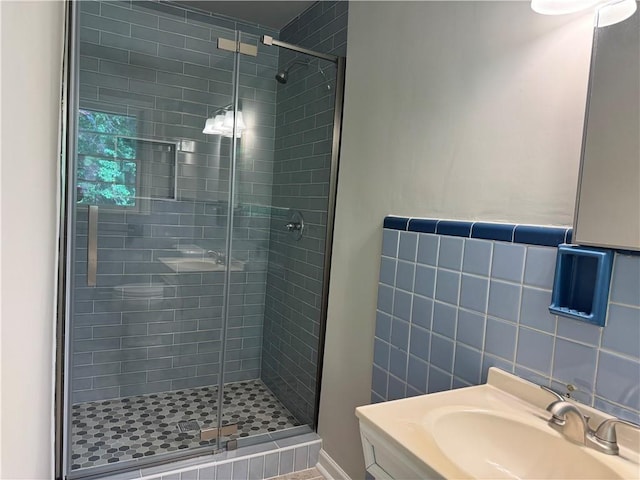 bathroom with a stall shower, tile walls, and a sink