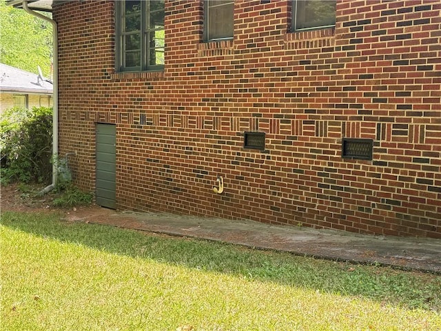 view of side of property with crawl space and brick siding