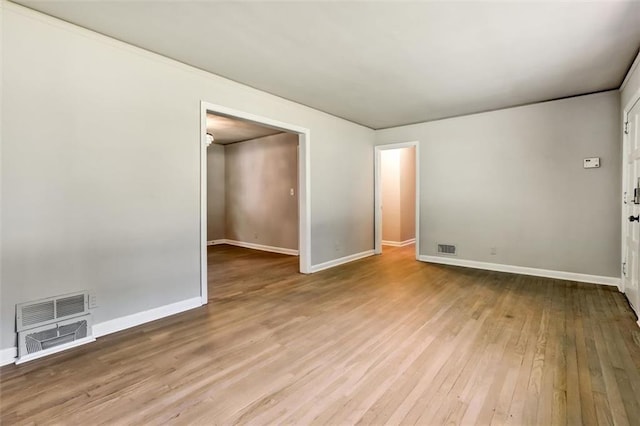 spare room featuring visible vents, hardwood / wood-style flooring, and baseboards