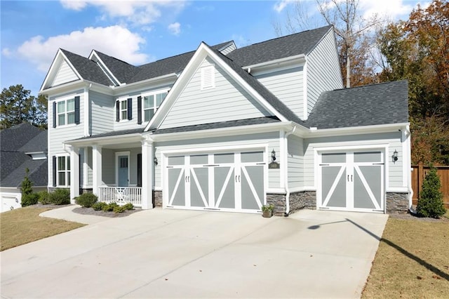 craftsman inspired home with a garage, a porch, and a front lawn