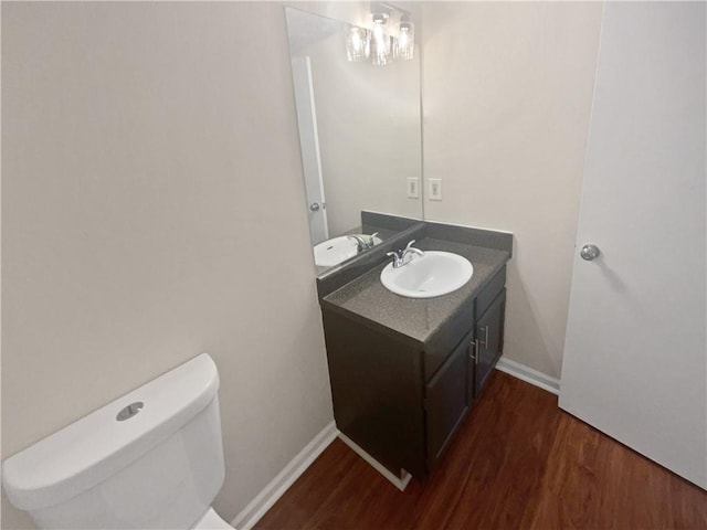 bathroom with toilet, hardwood / wood-style floors, and vanity