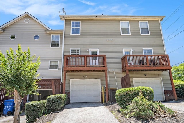 277 Ralph David Abernathy Blvd SW, Atlanta, GA 30312 - back of property featuring brick siding, a garage, asphalt driveway, and a balcony