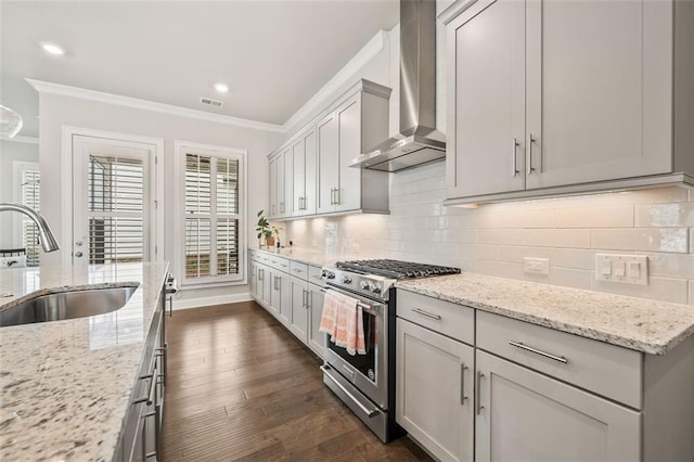 993 Harvest Park Ln, Suwanee, GA 30024 - kitchen featuring gas range, wall chimney range hood, crown molding, a sink, and dark wood-style flooring