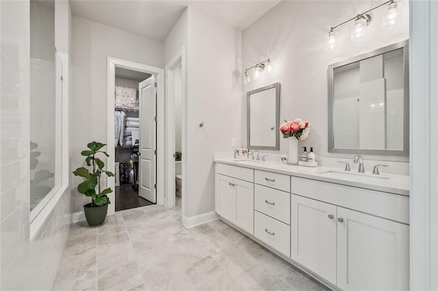 993 Harvest Park Ln, Suwanee, GA 30024 - full bathroom featuring double vanity, toilet, baseboards, a spacious closet, and a tile shower