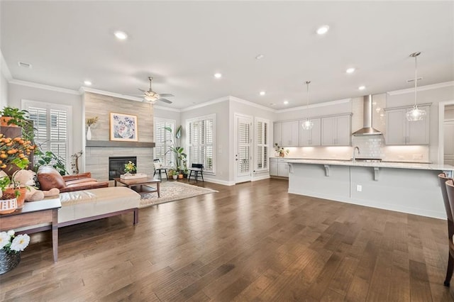 993 Harvest Park Ln, Suwanee, GA 30024 - living area with recessed lighting, a ceiling fan, dark wood-style floors, a tiled fireplace, and crown molding