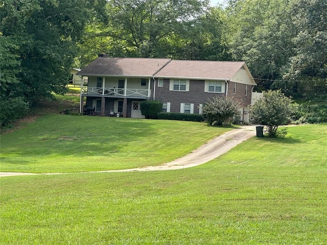 view of front of home featuring a balcony and a front yard