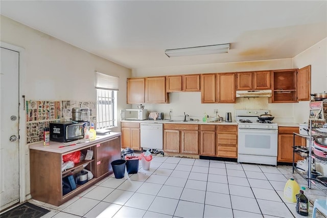 kitchen with white appliances, sink, and light tile floors