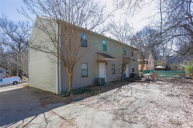 back of house with a swimming pool and central AC