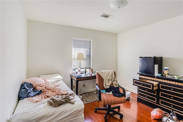 bedroom with dark hardwood / wood-style flooring