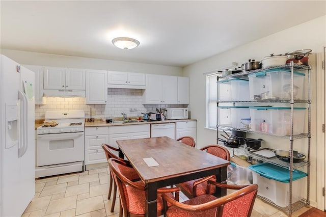 kitchen featuring white appliances, tasteful backsplash, light tile floors, and white cabinets