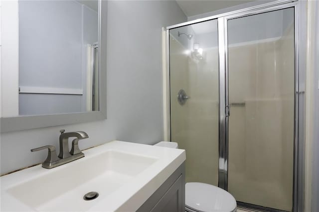 bathroom featuring vanity, a shower with door, and toilet