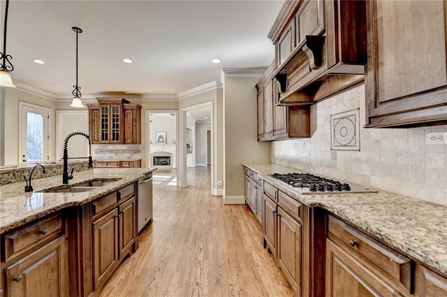 kitchen featuring light stone countertops, appliances with stainless steel finishes, hanging light fixtures, and sink