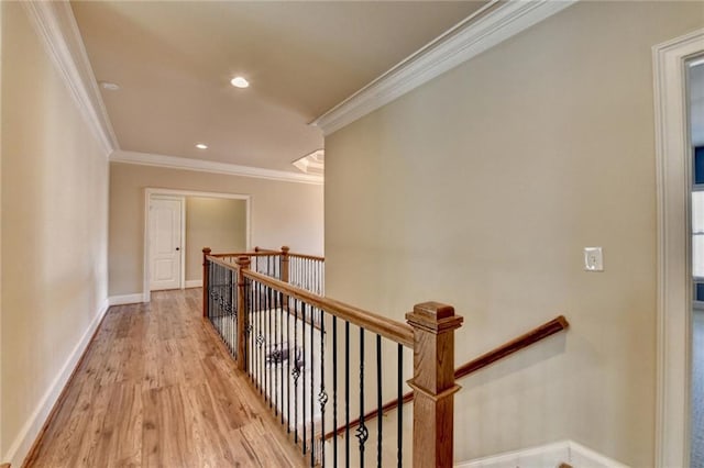 hallway with light wood-type flooring and crown molding