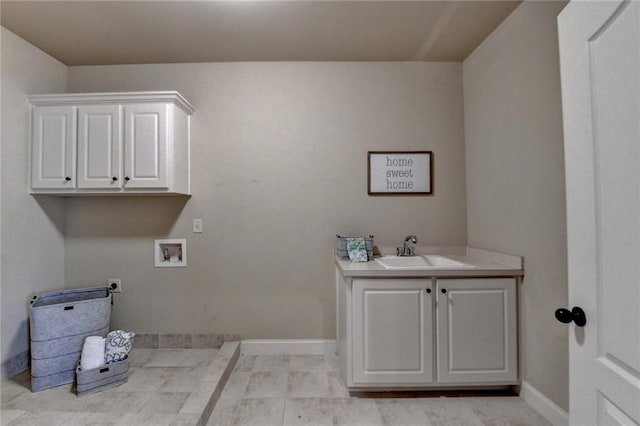 clothes washing area featuring sink, electric dryer hookup, cabinets, light tile patterned flooring, and washer hookup