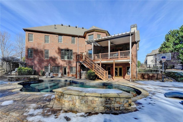 back of property with ceiling fan, a swimming pool with hot tub, and a patio area