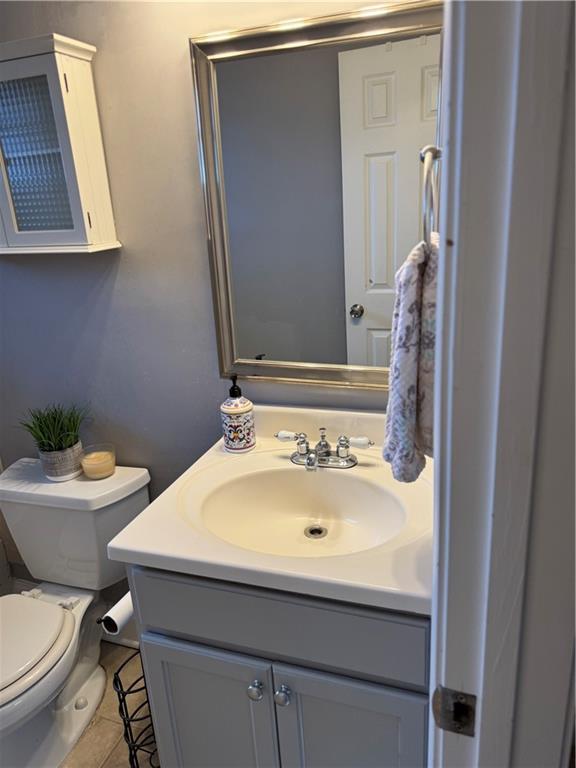 bathroom featuring toilet, vanity, and tile patterned flooring