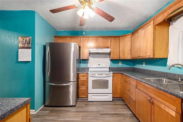 kitchen with dark wood-type flooring, stainless steel refrigerator, white electric range oven, ceiling fan, and sink