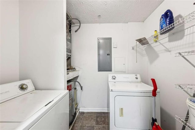 laundry area featuring washing machine and dryer, a textured ceiling, and electric panel