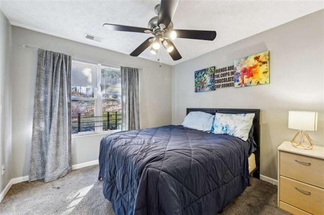 bedroom featuring multiple windows, dark carpet, and ceiling fan