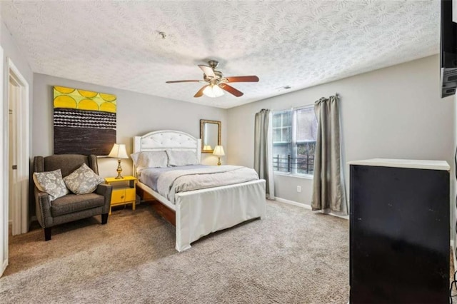 carpeted bedroom featuring ceiling fan and a textured ceiling