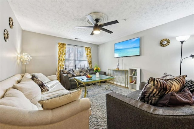 living room with ceiling fan and a textured ceiling