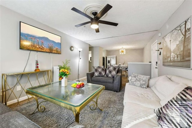 living room featuring ceiling fan and a textured ceiling