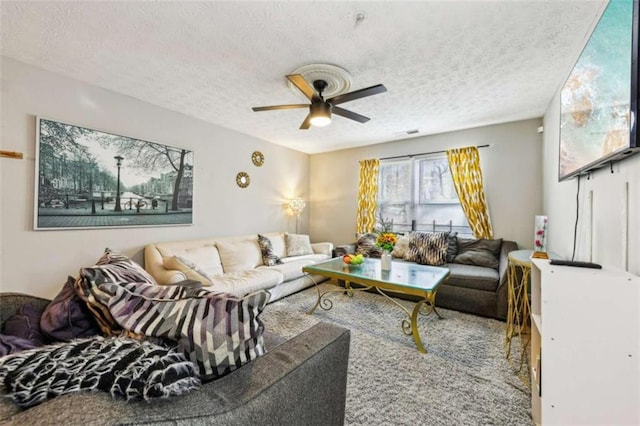 living room featuring ceiling fan and a textured ceiling