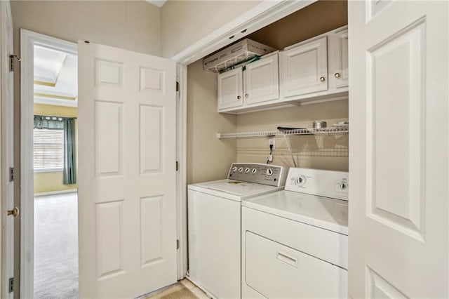 washroom with cabinet space, independent washer and dryer, and light carpet