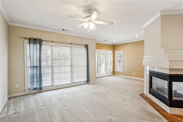 unfurnished living room with baseboards, visible vents, carpet floors, ornamental molding, and a tile fireplace