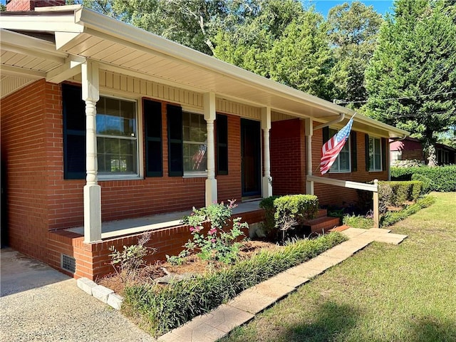 view of front of home featuring a porch, brick siding, and a front lawn