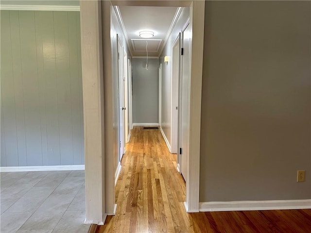 hall featuring baseboards, ornamental molding, light wood finished floors, and attic access