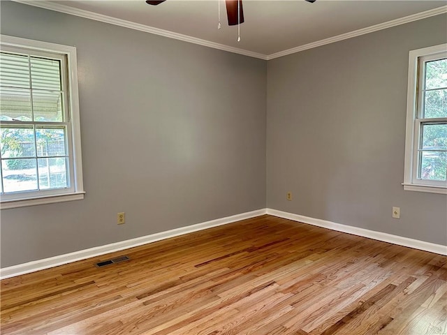 unfurnished room featuring visible vents, plenty of natural light, wood finished floors, and ceiling fan
