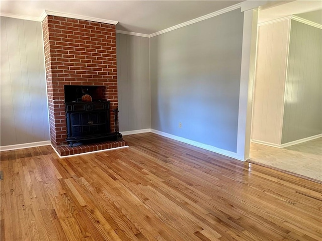 unfurnished living room featuring baseboards, ornamental molding, and wood finished floors