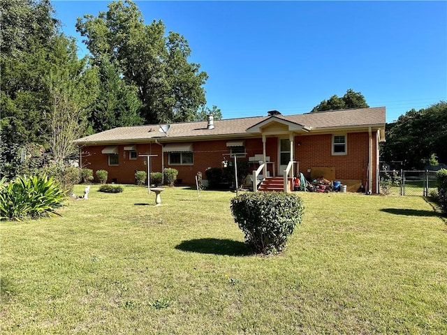 back of property featuring a lawn, brick siding, and fence