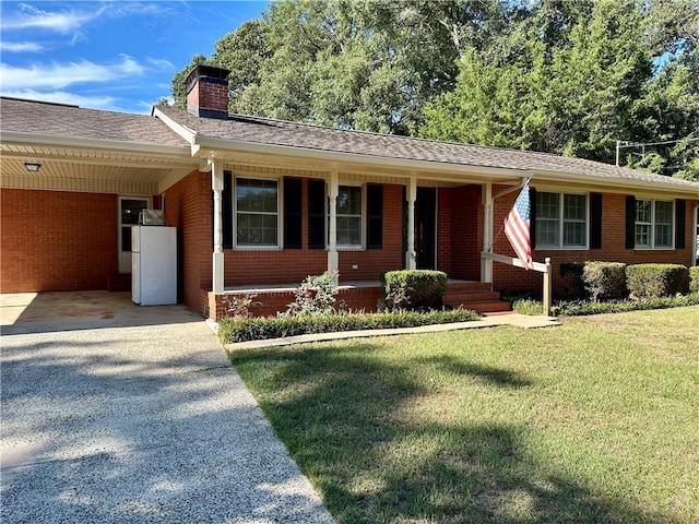 ranch-style house featuring a chimney, a front yard, brick siding, aphalt driveway, and an attached carport