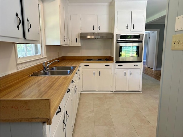 kitchen featuring white cabinets, oven, a sink, electric cooktop, and under cabinet range hood